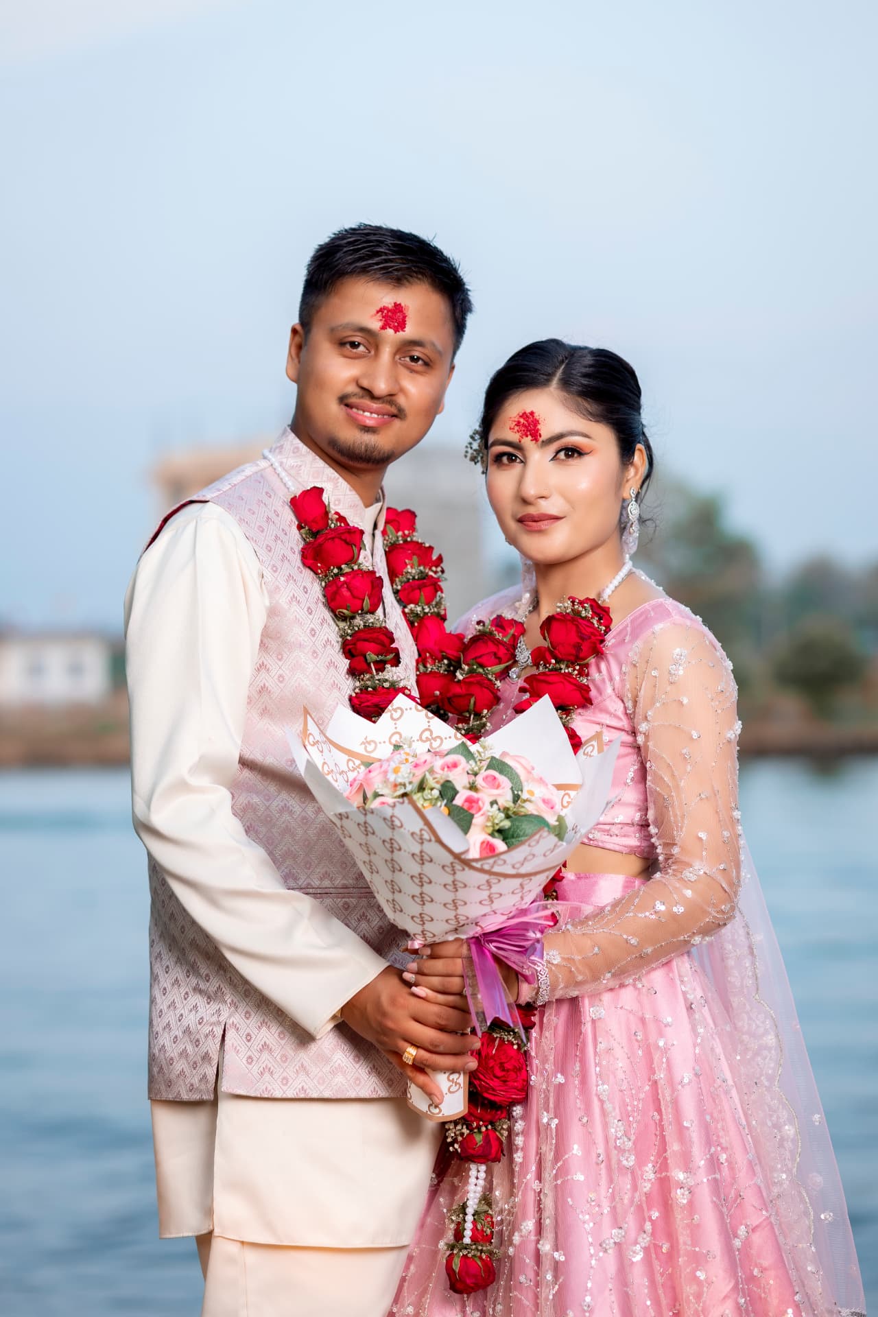 Wedding portrait by the riverside with flower garlands